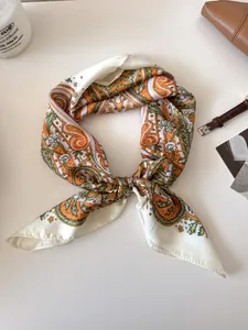 Detail shot of elegant retro paisley patterned silk square scarf tied in a stylish knot