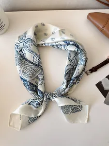 Detailed view of a retro paisley print silk square scarf for women in white and blue