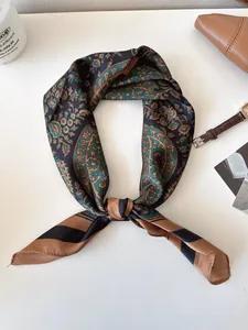 Detailed view of vintage paisley print silk-like square scarf arranged on white desk