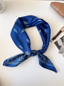 Elegant blue silk square scarf featuring a vintage white paisley pattern and tied knot detail.