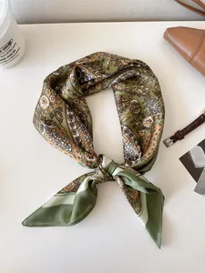 High-quality detail of a vintage paisley pattern silk scarf in olive green and gold
