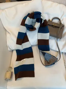 Dettaglio di una sciarpa in pura lana al 100% con strisce blu, marroni e azzurre.
