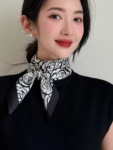 Close-up of a black and white rose pattern silk scarf tied around a woman's neck