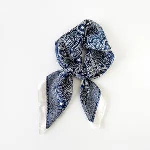 Primo piano dettagliato di un foulard in seta satinata con stampa paisley blu e bianco