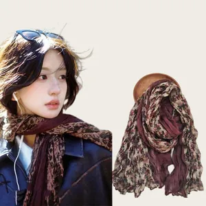Detail view of a vintage floral print scarf on a model and displayed separately