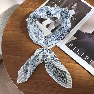 Close-up of pleated paisley silk scarf with vintage pattern and metal ring buckle