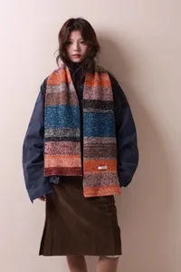 Dettaglio di una sciarpa in maglia a righe in pura lana indossata da una modella