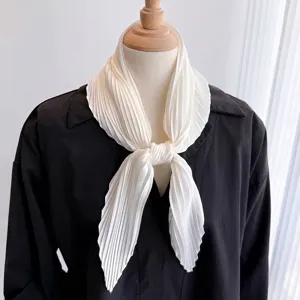 Close-up of cream white pleated scarf styled on a black shirt for a professional look