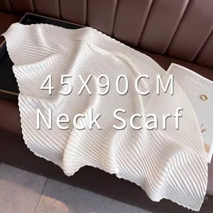 Detailed macro view of a pleated off-white silk scarf ribbon for professional outfits