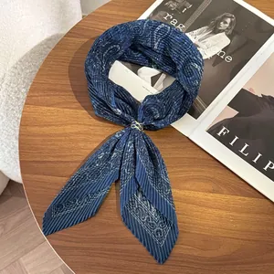 Close-up of pleated paisley silk scarf in deep blue with a vintage gold ring clip