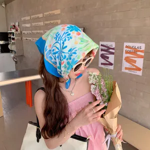 Stylish floral cotton-linen square headscarf worn by a woman in a cafe setting