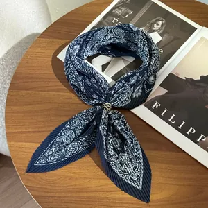 Detailed macro view of a navy blue pleated paisley scarf with gold ring buckle.