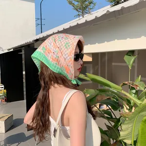 Asian model wearing an orange floral cotton linen headscarf in an outdoor setting