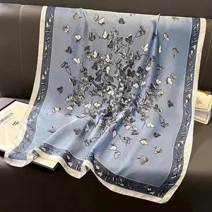 Detailansicht eines eleganten blauen Seidenschals mit schwarzem Schmetterlingsdruck