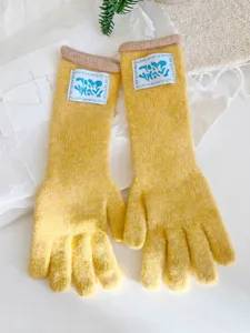 Detalle de guantes largos de punto amarillos para invierno con parche