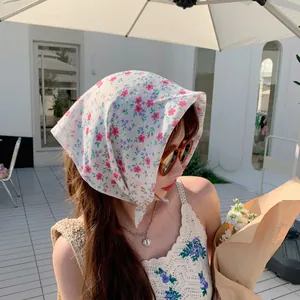 Close-up of floral cotton linen headscarf worn by a model in a summer outdoor setting.