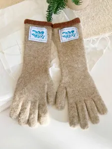Vista detallada de guantes de invierno de punto largo beige con parche de etiqueta