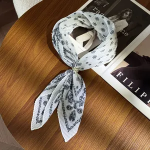 Close-up of pleated paisley scarf with vintage floral prints on a wooden table