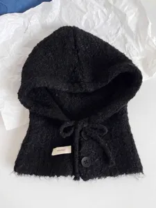 Nahaufnahme einer schwarzen, flauschigen Strick-Balaclava aus Wolle mit Knöpfen