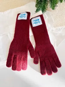 Detalle de guantes de invierno largos de punto burdeos con puños de forro polar