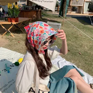Close-up of a model wearing a 58cm colorful floral cotton linen headscarf outdoors