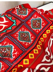 Macro view of red ethnic style shawl showing intricate geometric patterns and fabric texture