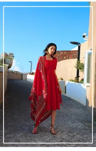 Detail view of ethnic style red patterned shawl draped over a matching red dress