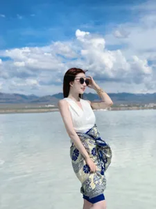 A woman elegantly wearing an ethnic blue elephant print shawl as a wrap skirt at a salt lake