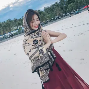 Ethnic style large shawl with intricate patterns worn by a woman on a sunny beach