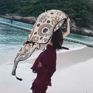Elegant back view of a woman holding an ethnic style elephant print shawl on a beach