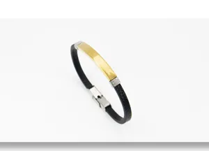 Primer plano de elegante pulsera de cuero negro con una placa de metal dorado lisa
