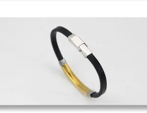 Primer plano de pulsera de cuero negro vintage con placa de metal dorado pulido