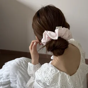 Chouchou élégant en tissu rose sur chignon, élastique à cheveux haute élasticité