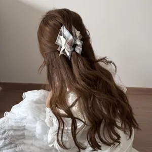 Gedetailleerd beeld van geruite scrunchie met kant op golvend haar.