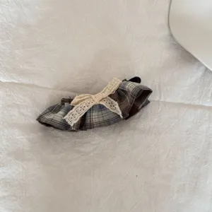 Detail van een geruite scrunchie met ruches en een delicate kanten strik voor haarstijl
