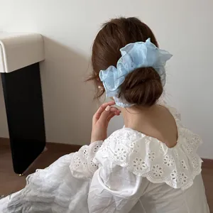 Detailansicht eines großen hellblauen Haargummis aus Organza für einen Dutt