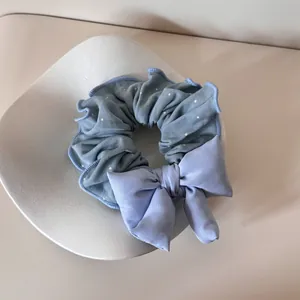 Detailansicht eines blauen gepunkteten Haargummis mit einer großen Stoffschleife
