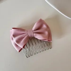 Elegant pink satin bow hair comb detail with silver metal teeth for hair styling