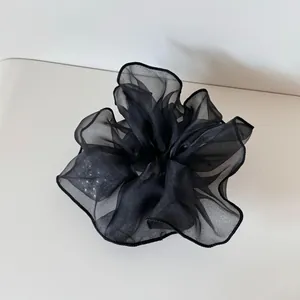 Detailansicht eines schwarzen Organza-Haargummis mit atmungsaktiver, leichter Textur