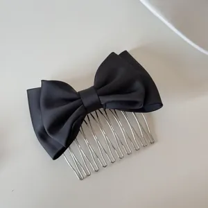 Elegant black satin bow hair comb with silver metal prongs for various hair styles.