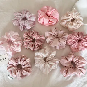 Détail d'un lot de chouchous en tissu duveteux crème et rose avec divers motifs variés