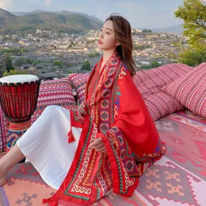 Ethnic style red shawl with tribal patterns and tassels for outdoor travel photography.