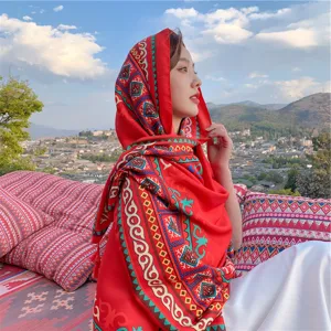 Vibrant red ethnic style shawl with bohemian patterns worn by a woman outdoors.