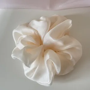 Detailed view of the soft mesh texture on an off-white oversized scrunchie