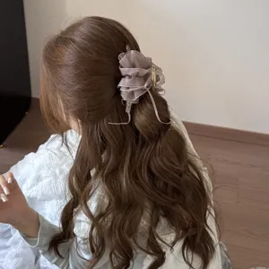 Detail view of an elegant tulle mesh hair claw clip in a dusty rose color