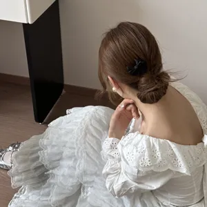 Elegante detalle de peine para el cabello con lazo negro en un peinado de moño trenzado.