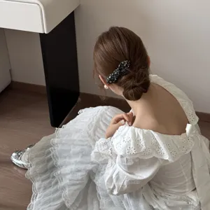 Close-up of vintage floral bow hair clip on model's bun hairstyle