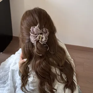 Detail of elegant mauve mesh bubble hair claw clip on a half-up wavy hairstyle.
