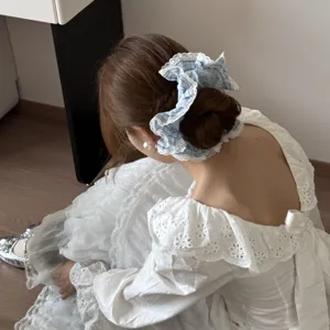 Elegant blue plaid oversized hair scrunchie with lace trim shown on a bun style.