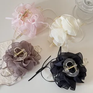 Detailed view of four elegant mesh gauze hair claws in pink, cream, mauve and black